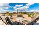 Scenic back patio features a stone surface and comfortable seating with views of desert landscape and mountains at 7380 E Canyon Wren Dr, Gold Canyon, AZ 85118