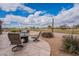 Scenic backyard with a stone patio and comfortable seating, perfect for enjoying views of desert and a golf course at 7380 E Canyon Wren Dr, Gold Canyon, AZ 85118