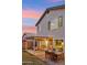 Backyard view of a home, highlighting a patio with dining and relaxing areas at dusk at 741 N Cholla St, Chandler, AZ 85224