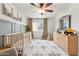 Bedroom features wood floors, crib, dresser with decor, and a view of the tree-lined street at 741 N Cholla St, Chandler, AZ 85224