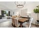 Open concept dining area featuring a sleek chandelier, view to the living room, and modern decor at 741 N Cholla St, Chandler, AZ 85224