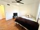 Inviting bedroom featuring hardwood flooring, a ceiling fan, cozy bed, and comfortable decor at 817 N 95Th Pl, Mesa, AZ 85207