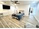 Spacious main bedroom with plank tile flooring, ceiling fan and large flat screen TV at 817 N 95Th Pl, Mesa, AZ 85207