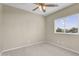 Serene bedroom featuring carpet, fan, and large window providing ample natural light and neighborhood views at 863 E Waterview Pl, Chandler, AZ 85249