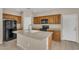 Functional kitchen featuring an island with a sink, black appliances, and wood cabinets, ready for your culinary touch at 863 E Waterview Pl, Chandler, AZ 85249