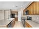 Well-lit kitchen features wooden cabinets, modern black appliances, and tile flooring at 863 E Waterview Pl, Chandler, AZ 85249