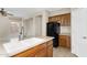 Kitchen island with a stainless steel sink with wooden cabinets and black refrigerator at 863 E Waterview Pl, Chandler, AZ 85249