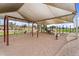 Community playground featuring swings, slides, and a shaded play area with play equipment over a large sand area at 863 E Waterview Pl, Chandler, AZ 85249