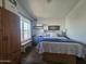 Comfortable bedroom featuring a bed with blue accents, wood floors, and ample natural light at 8700 E University Dr # 649, Mesa, AZ 85207