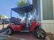Eye-level full view of a red golf cart with black seats and roof, parked on a brick surface at 8700 E University Dr # 649, Mesa, AZ 85207