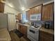 Well-lit kitchen featuring a range, microwave, and cabinetry, providing a functional culinary area at 8700 E University Dr # 649, Mesa, AZ 85207