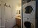A laundry area with stacked washer and dryer adjacent to a bathroom with a vanity and mirror at 8700 E University Dr # 649, Mesa, AZ 85207