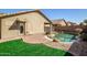 Lush backyard featuring a sparkling pool, landscaped areas, and an outdoor patio at 9331 W Harmony Ln, Peoria, AZ 85382