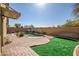 Backyard with a pool, artificial turf, and a brick-paved patio, perfect for outdoor relaxation at 9331 W Harmony Ln, Peoria, AZ 85382