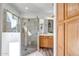 Well-lit bathroom featuring glass shower with stone tile accents, wood cabinets, and wood-look flooring at 9331 W Harmony Ln, Peoria, AZ 85382