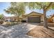 Expansive driveway leading to a home with a two-car garage, complemented by mature landscaping at 9331 W Harmony Ln, Peoria, AZ 85382