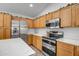 Bright kitchen boasting stainless steel appliances, light wood cabinets, and white countertops at 9331 W Harmony Ln, Peoria, AZ 85382