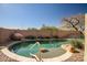 Backyard showcasing a refreshing in-ground pool with desert landscaping and a brick privacy wall at 9331 W Harmony Ln, Peoria, AZ 85382