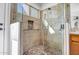 Tiled shower with glass door, stone floors, inset shelf, and a dual shower head at 9331 W Harmony Ln, Peoria, AZ 85382