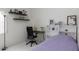 Cozy bedroom with functional shelves, desk, and neutral colored walls for a versatile space at 1009 E Brentrup Dr, Tempe, AZ 85283