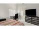 Bedroom featuring a desk, TV, and a glimpse into a bathroom with a soaking tub at 1009 E Brentrup Dr, Tempe, AZ 85283