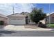 Tan single-story home featuring a two-car garage and tile roof in a quiet neighborhood at 1009 E Brentrup Dr, Tempe, AZ 85283
