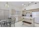 Bright kitchen with white appliances, light wood cabinetry, and space for a breakfast table at 1009 E Brentrup Dr, Tempe, AZ 85283