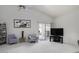 Bright living room with access to backyard patio, neutral color scheme and a ceiling fan at 1009 E Brentrup Dr, Tempe, AZ 85283