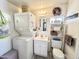 Small, compact bathroom featuring white cabinets, sink, mirror, toilet and stacked washer and dryer at 1027 S Prospector Dr, Apache Junction, AZ 85119