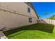 Side view of a home's backyard with well-maintained lawn and block wall for enhanced privacy at 1027 W Natal Ave, Mesa, AZ 85210