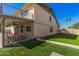 Exterior view of home, displaying a balcony, covered patio, lush lawn, and privacy fence at 1027 W Natal Ave, Mesa, AZ 85210