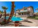 Large backyard features private pool, diving board, covered patio, rock landscaping, and mature trees under a bright blue sky at 1027 W Natal Ave, Mesa, AZ 85210