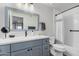 Modern bathroom features a blue vanity, white quartz countertop, black hardware, and subway tile backsplash at 1027 W Natal Ave, Mesa, AZ 85210