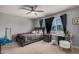 Cozy bedroom featuring a ceiling fan, gray walls, and an updated window with privacy blinds at 1027 W Natal Ave, Mesa, AZ 85210