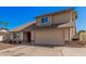 Tan two story home with front yard, two car garage, red brick detail, and blue skies at 1027 W Natal Ave, Mesa, AZ 85210