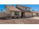 A tan two-story home featuring a two-car garage and a low-maintenance rock front yard at 1027 W Natal Ave, Mesa, AZ 85210