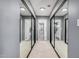Hallway featuring a full wall of mirrored closets leading to a bathroom with glass shower at 1027 W Natal Ave, Mesa, AZ 85210