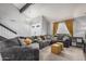 Bright living room with a vaulted ceiling, exposed beams, a large gray couch, and gold accents at 1027 W Natal Ave, Mesa, AZ 85210