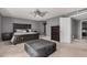 Spacious main bedroom featuring a ceiling fan, gray walls, and a king bed with a gray ottoman at 1027 W Natal Ave, Mesa, AZ 85210