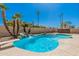 Large backyard featuring diving board, private pool, spa, waterfall feature, tropical landscaping, and comfortable seating at 1027 W Natal Ave, Mesa, AZ 85210