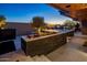 Desert backyard with a sleek outdoor dining area, fire pit, and tasteful landscaping at 10381 E Loving Tree Ln, Scottsdale, AZ 85262