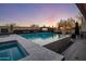 Expansive backyard features a sparkling pool, hot tub, fire pit, desert landscaping and a sunset view at 10381 E Loving Tree Ln, Scottsdale, AZ 85262