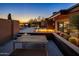 Stunning backyard features a fire pit, pool, desert landscaping, and a modern outdoor dining space at 10381 E Loving Tree Ln, Scottsdale, AZ 85262