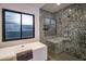 Modern bathroom featuring a tub and walk in shower with stunning stone tile at 10381 E Loving Tree Ln, Scottsdale, AZ 85262
