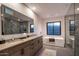 Sleek, modern bathroom featuring dual sinks, wood-look cabinets, and a luxurious shower and soaking tub at 10381 E Loving Tree Ln, Scottsdale, AZ 85262