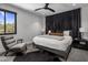 Modern bedroom featuring a plush bed, stylish furnishings, and a window with a scenic desert view at 10381 E Loving Tree Ln, Scottsdale, AZ 85262
