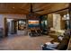 Inviting covered patio features a TV, stone accents, and comfortable seating at 10381 E Loving Tree Ln, Scottsdale, AZ 85262
