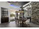 Elegant dining room with statement lighting and a stunning wine display at 10381 E Loving Tree Ln, Scottsdale, AZ 85262