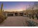 Beautiful exterior view of home with a private driveway, desert landscape, and sunset sky at 10381 E Loving Tree Ln, Scottsdale, AZ 85262