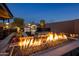 Backyard fire pit and outdoor kitchen offer a perfect space for entertaining at 10381 E Loving Tree Ln, Scottsdale, AZ 85262